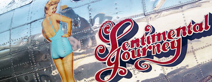 The image features a vintage aircraft with a retro pin-up girl and the text "Sentimental Journey" on its shiny surface.