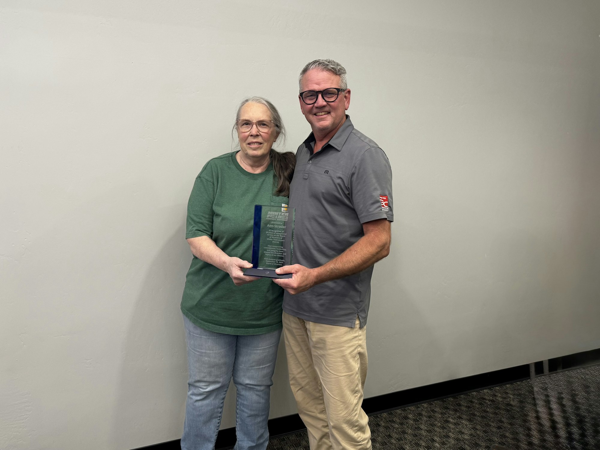 Director Strader and Director Weishaar with a commemorative plaque honoring her decades of dedication to the District.