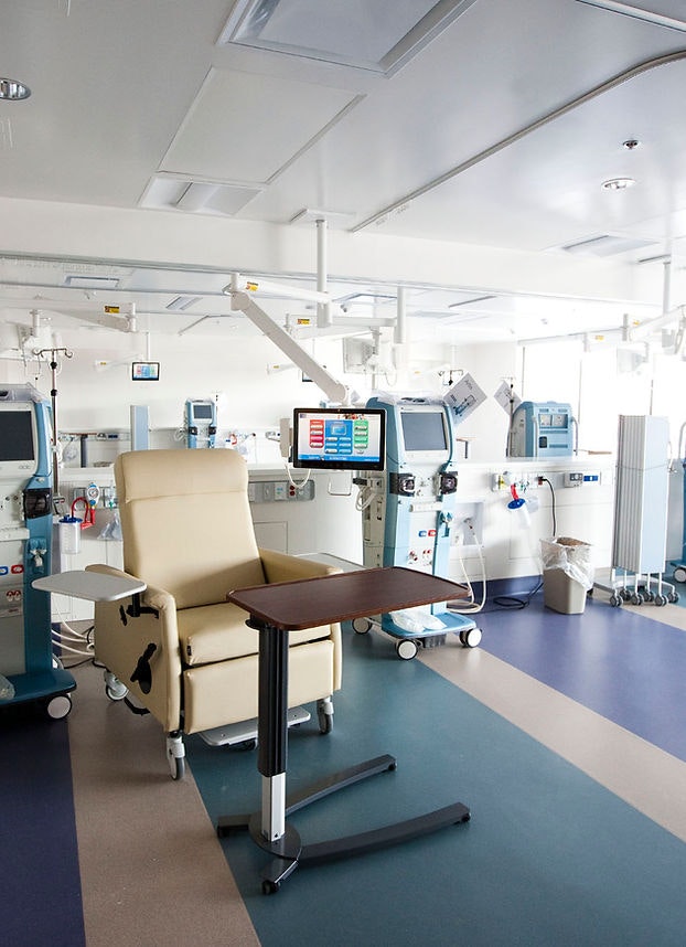 A hospital room with medical equipment, a reclining chair, and monitors.