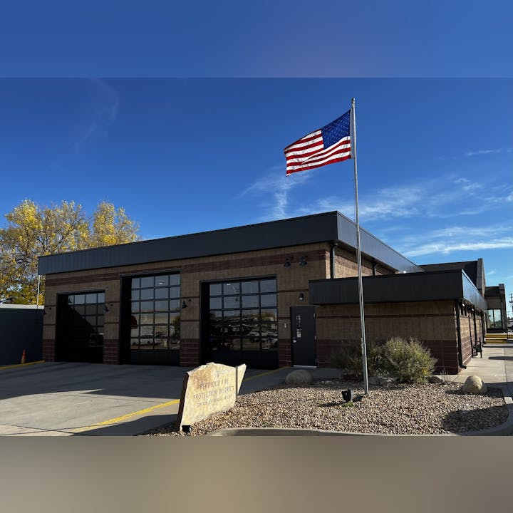 Fire station with an American flag, clear sky.