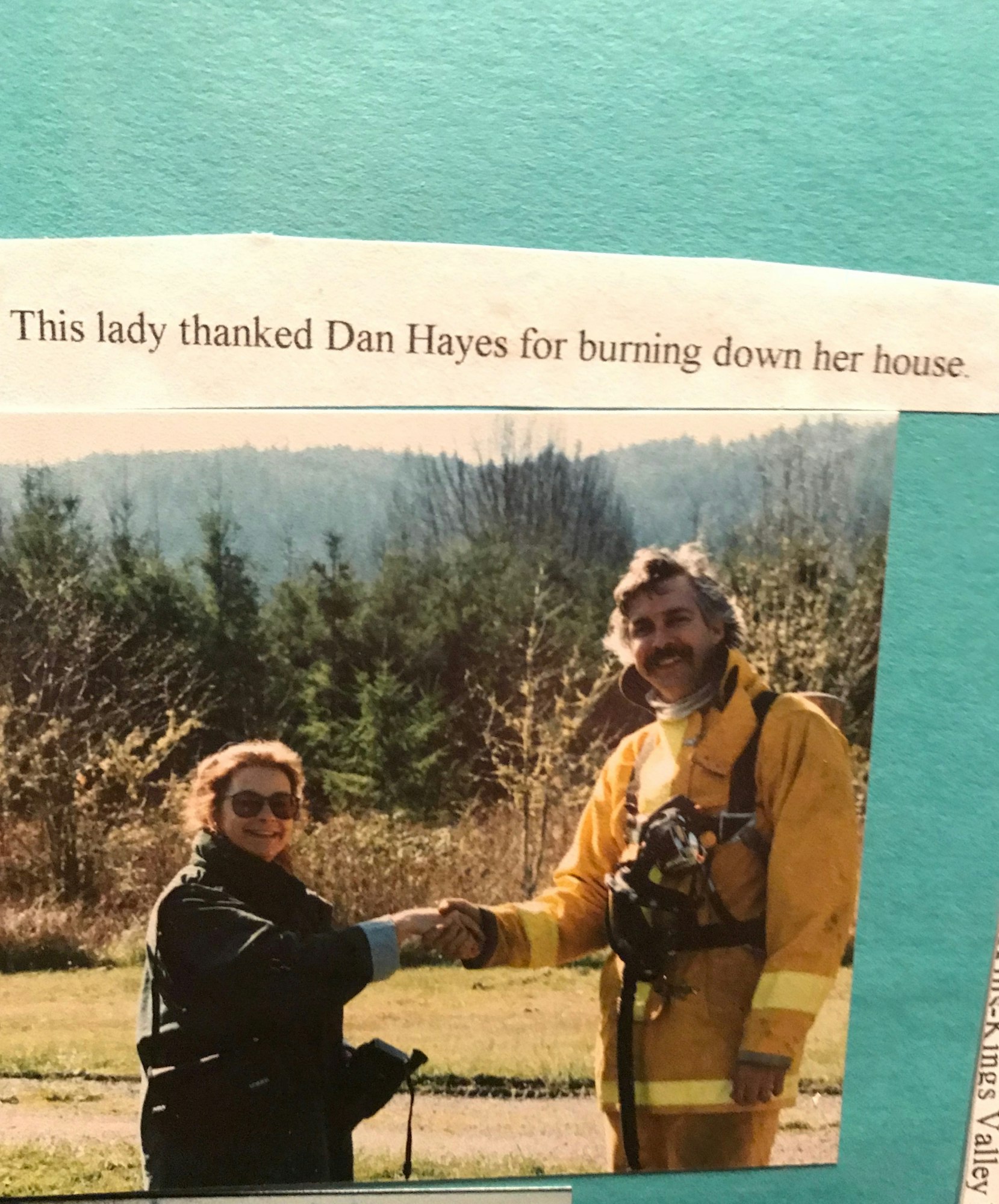 A woman is thanking Dan Hayes, likely a firefighter, for burning down her house, possibly for a controlled burn.