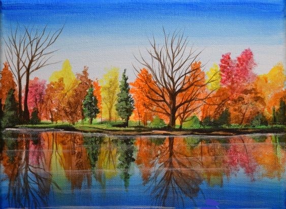 Colorful autumn trees reflected in a calm lake under a clear blue sky.