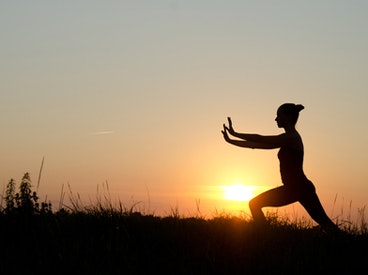 Silhouette of a person doing yoga at sunset.