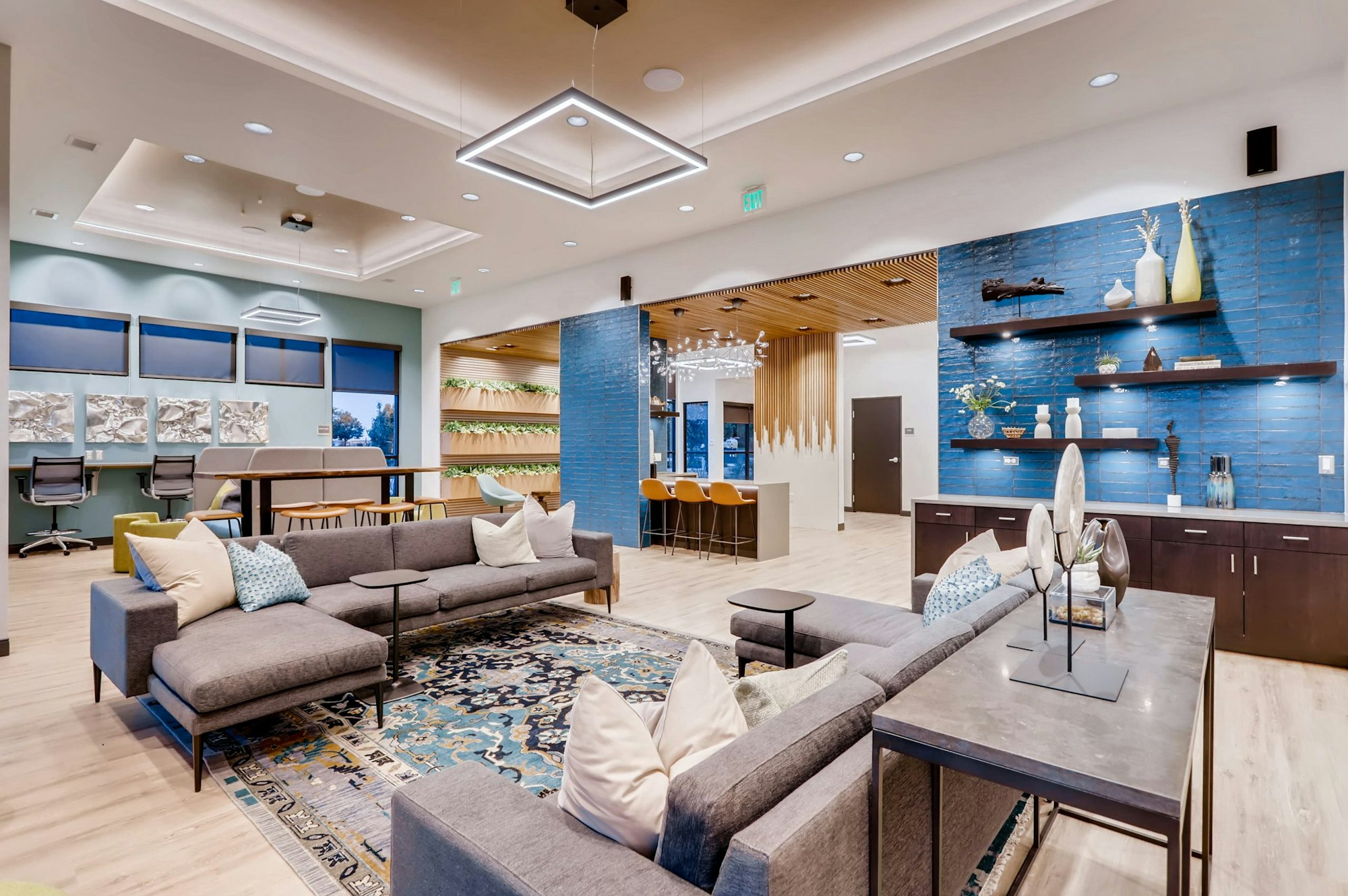 Modern lobby with sofas, decorative shelves, and a blue accent wall.