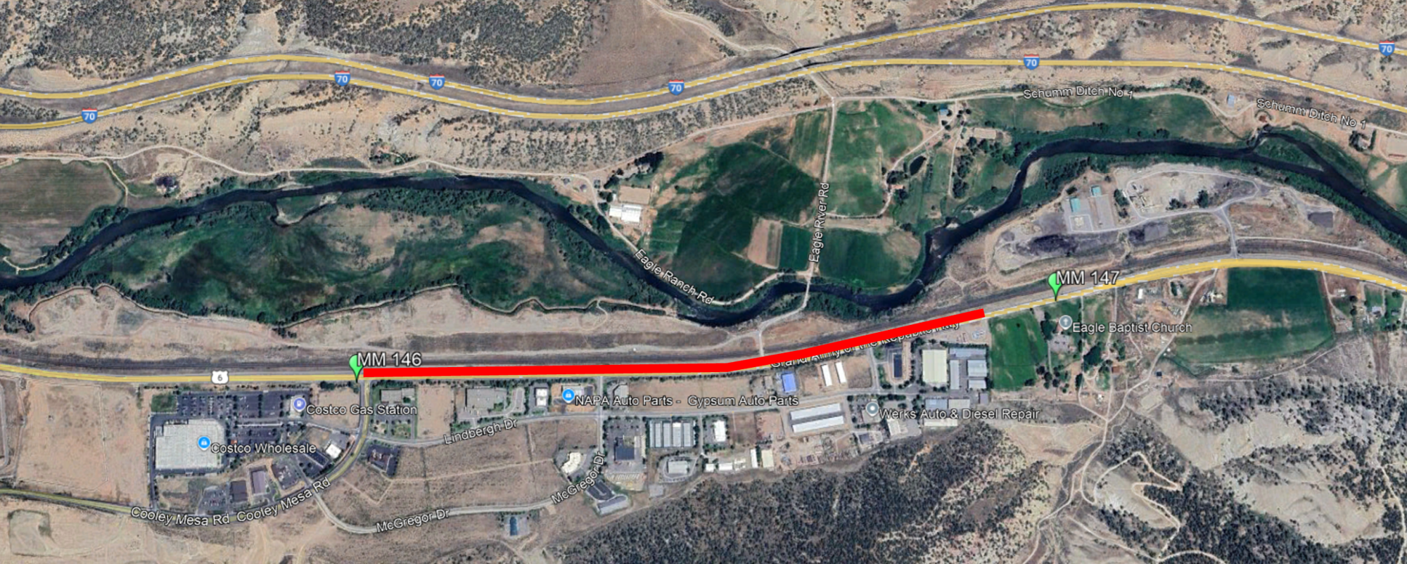 Satellite image of a highway area with a marked red route, nearby businesses, river, and roads labeled.