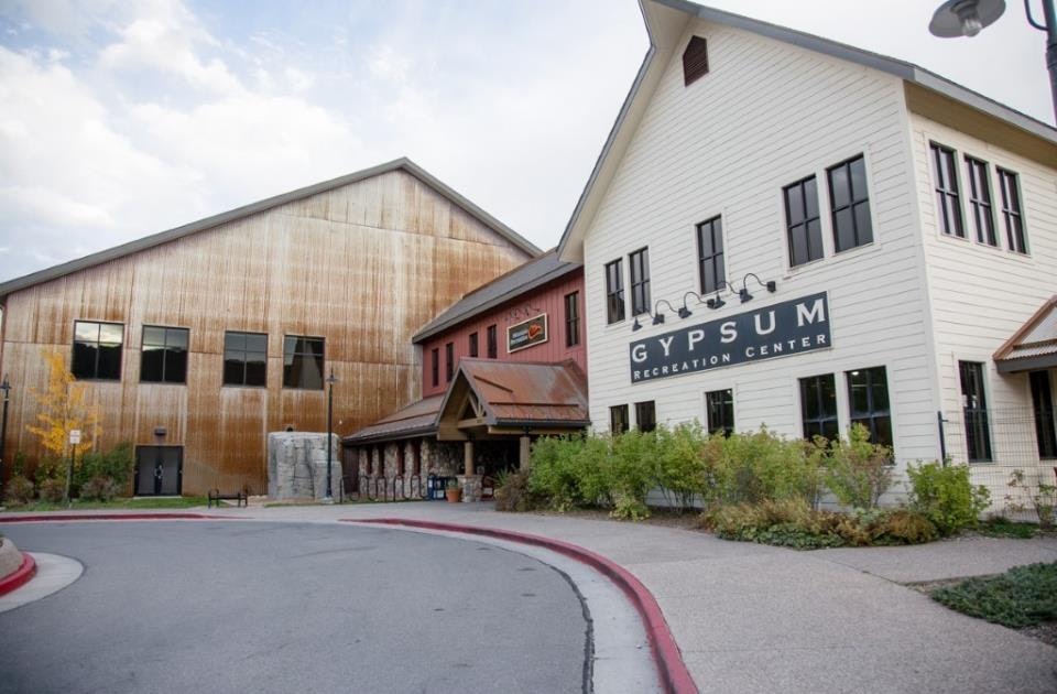 A recreation center with a white and brown building, labeled "Gypsum Recreation Center," with a parking lot in front.