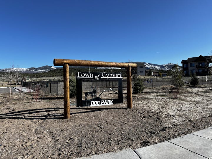 Sign for Town of Gypsum Dog Park, set in a mountainous landscape with a clear blue sky.