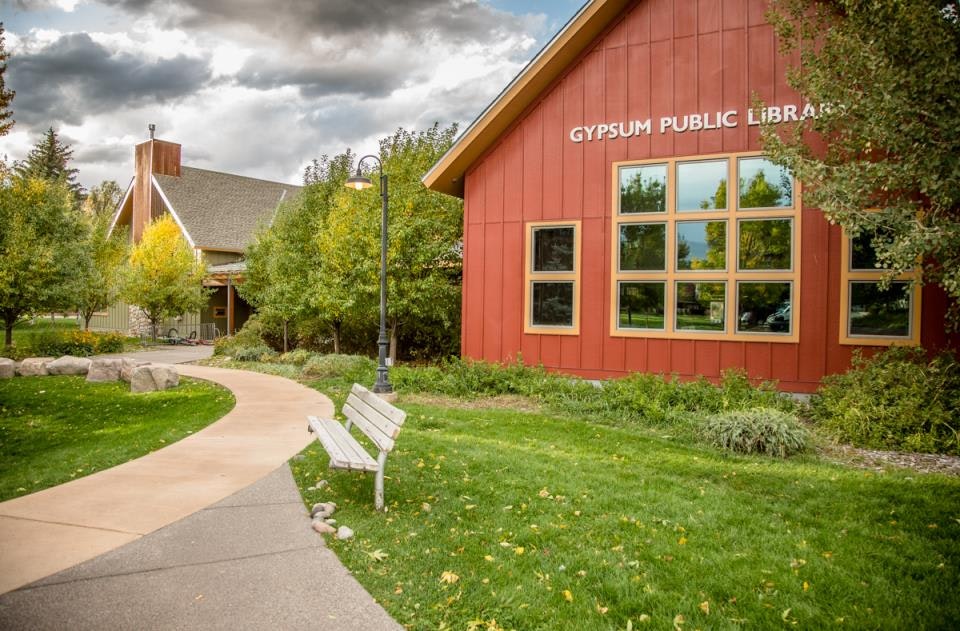 Gypsum Public Library with a pathway, benches, and surrounding greenery.