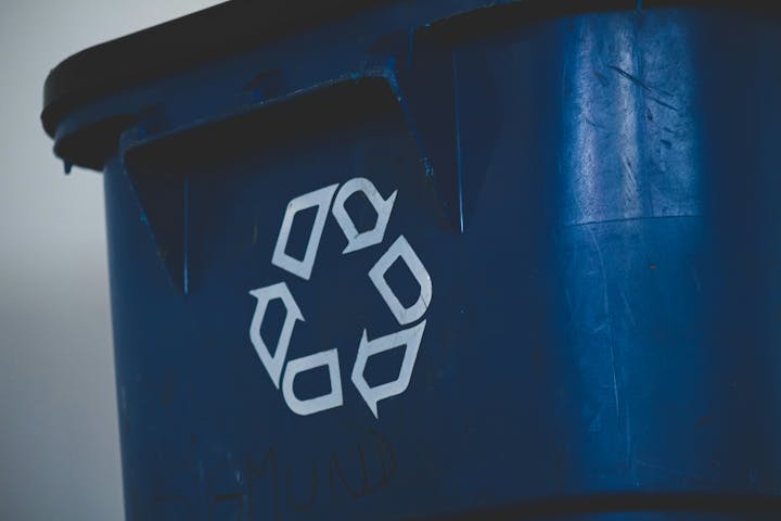 Blue recycling bin with a white recycling symbol.