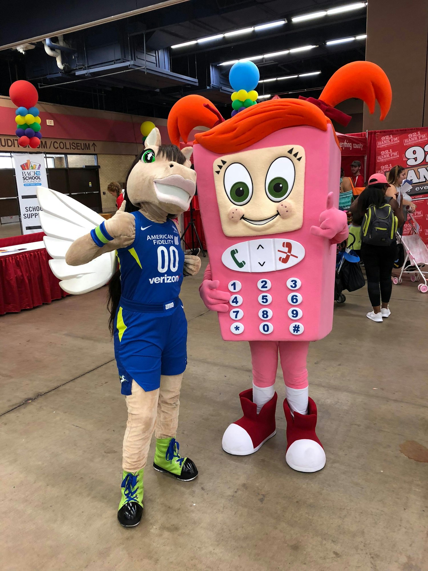 Costumed characters resembling a horse and a mobile phone keypad at an event.
