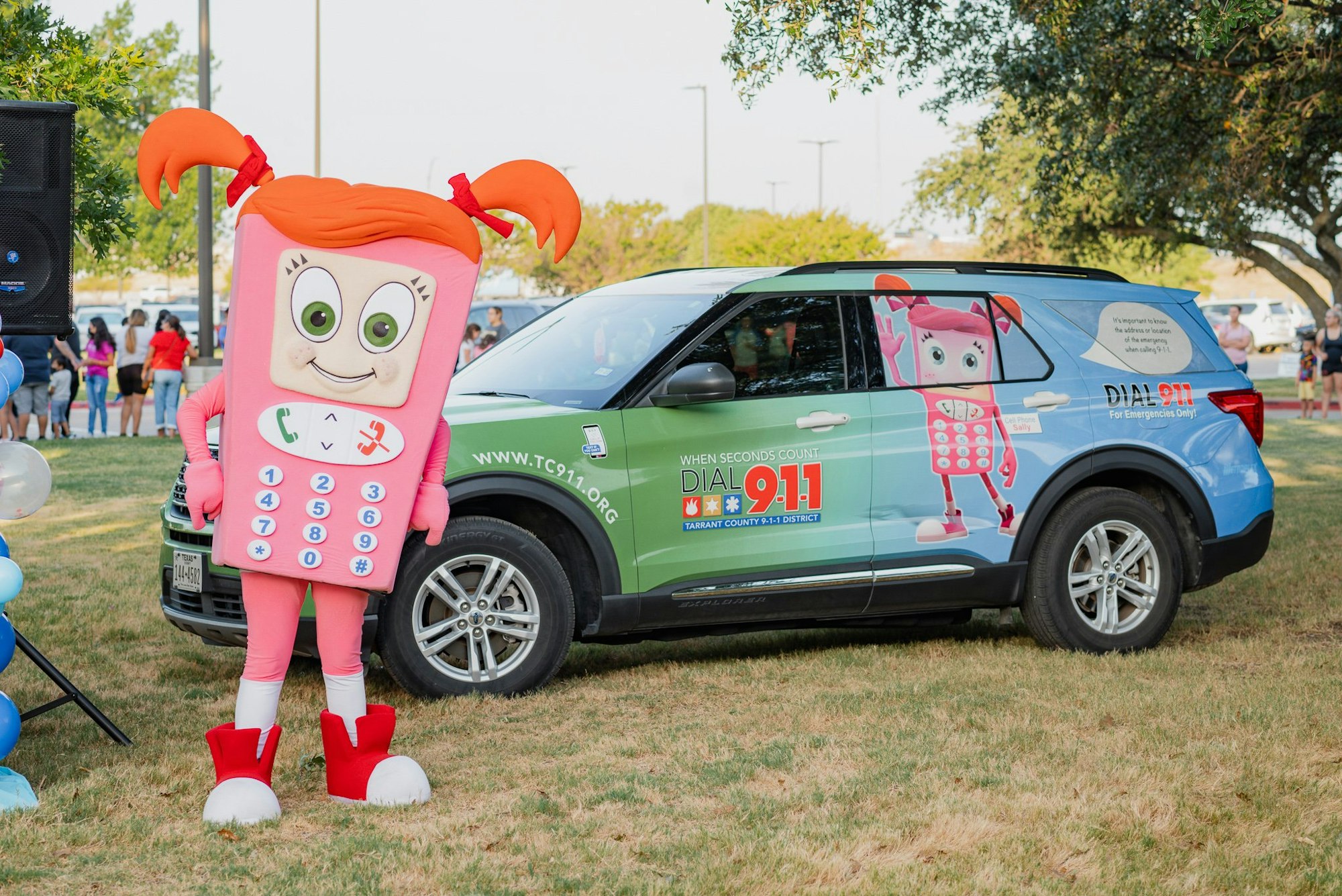 Person in phone costume and car promoting 911 emergency services.