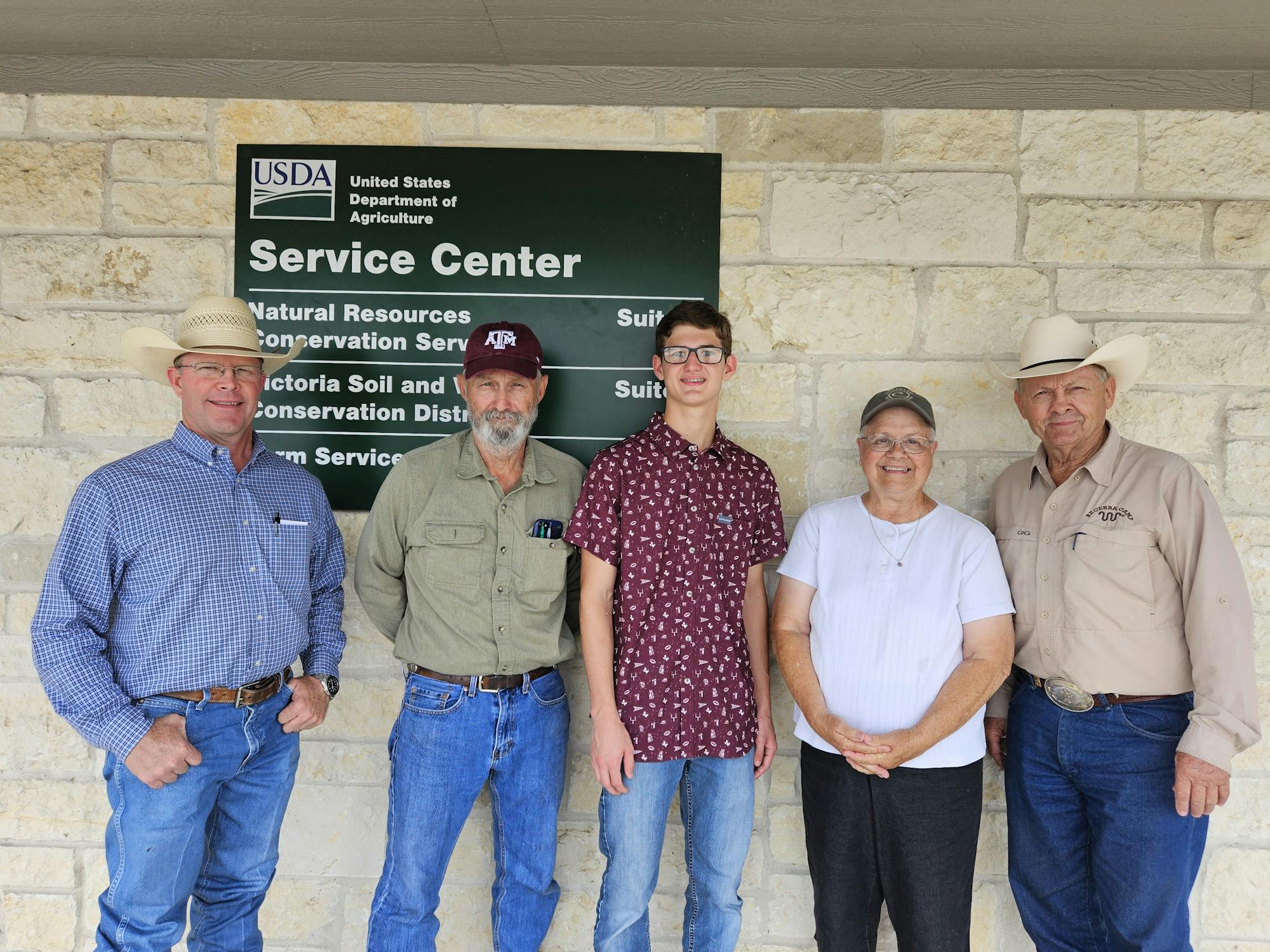 Five people standing in front of a USDA Service Center sign.