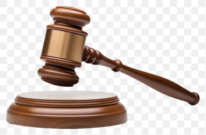 A wooden gavel about to strike a sound block.