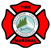 A badge with "Jefferson County Washington FIRE MARSHAL" around a red maltese cross with a green tree and a mountain.