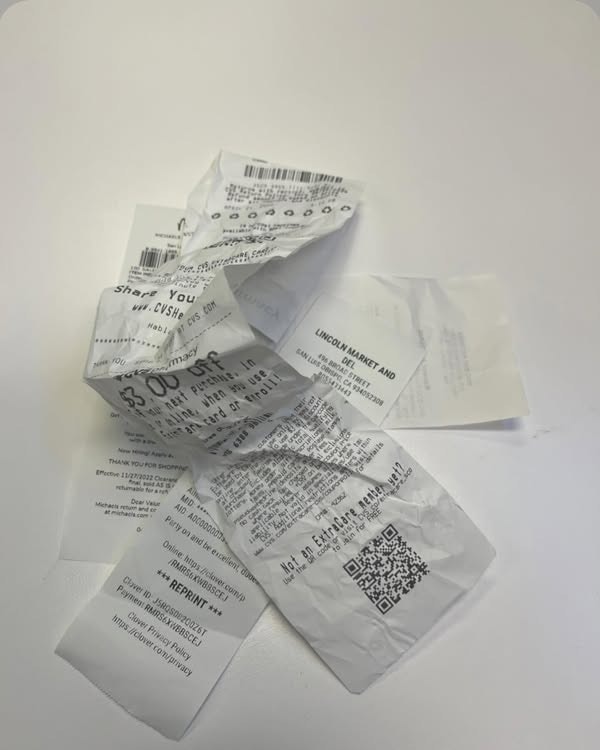 Crumpled receipts on a white surface, featuring a QR code and text.