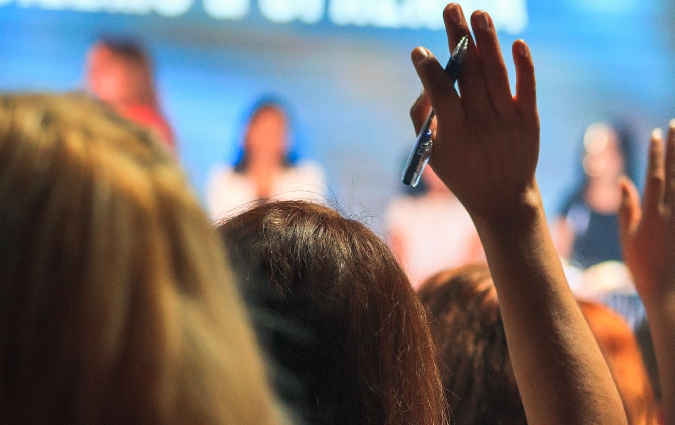 Person raising hand at a meeting