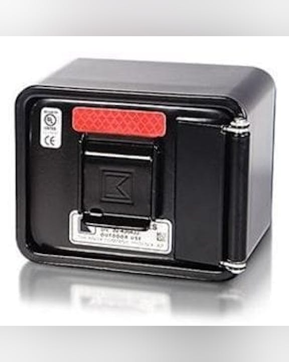 The image shows a small black box with a red label and a latch, possibly a secure storage container or device.
