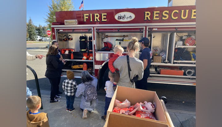 May contain: clothing, footwear, shoe, hat, flag, person, box, boy, child, male, adult, female, woman, backpack, bag, road sign, sign, symbol, accessories, handbag, transportation, truck, and vehicle