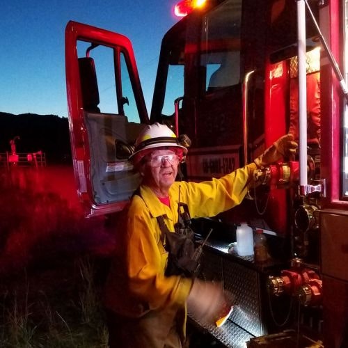 firefighter leaning against an apparatus