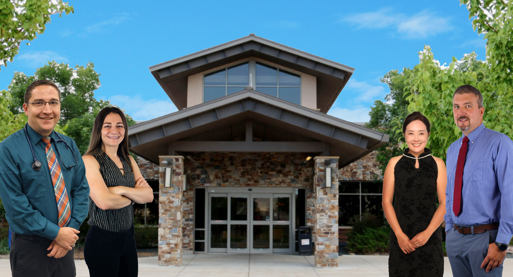 Four people standing in front of a stone building with greenery and a blue sky.
