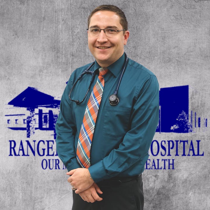 A person in medical attire with a stethoscope, standing in front of a background with a hospital logo.