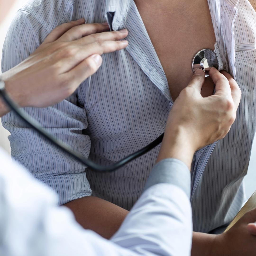 A doctor is using a stethoscope to examine a patient’s chest, with a focus on health checkup.