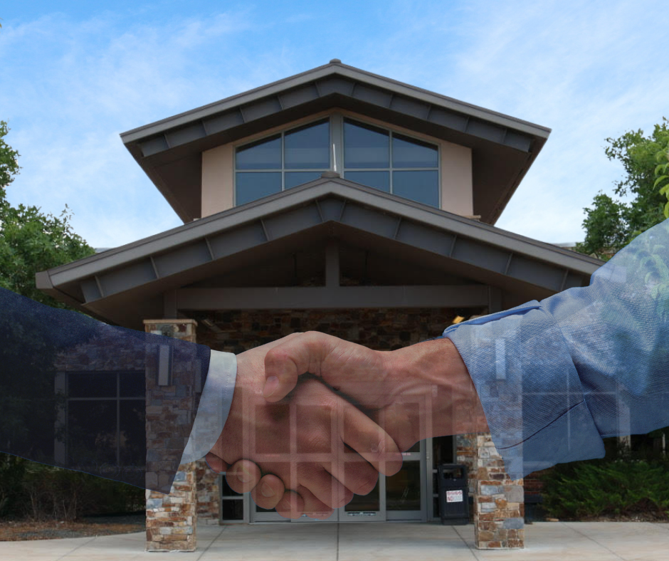 A handshake superimposed over a building exterior, symbolizing an agreement or deal.