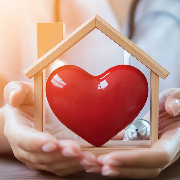 An image featuring a red heart inside a wooden house, symbolizing care, love, and home.