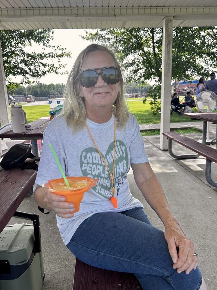 May contain: clothing, t-shirt, face, head, person, photography, portrait, architecture, building, outdoors, shelter, accessories, sunglasses, summer, sitting, grass, plant, adult, female, woman, nature, park, jeans, pants, furniture, house, housing, porch, glasses, table, and tree