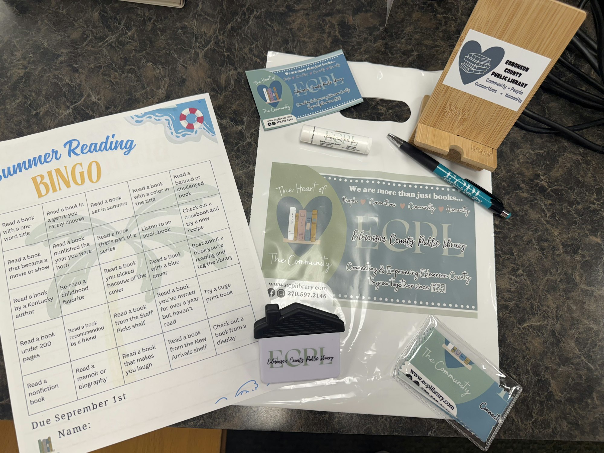 Summer Reading BINGO card, library promotional items, pen, cardholder, and info from Edmonson County Public Library.
