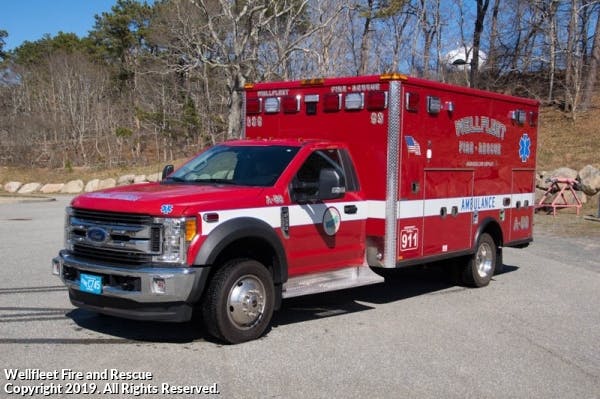 A red ambulance with "Wellfleet Fire-Rescue" and "911" markings, parked outdoors.