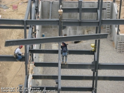 Workers on a steel framework of a construction site.