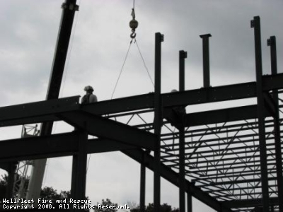 Construction site with steel framework and a worker.