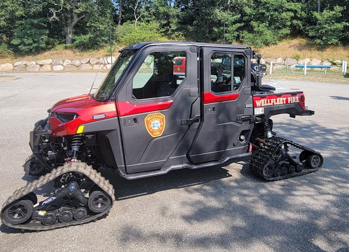 A tracked utility vehicle with "Wellfleet Fire" branding.
