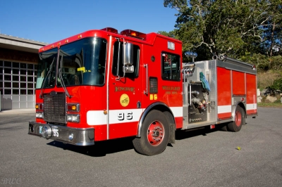 A red fire engine parked outside on a sunny day.
