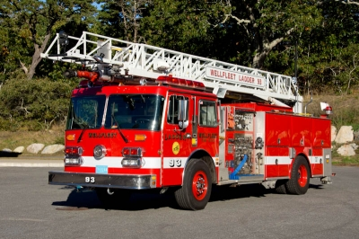 A red fire truck with a ladder parked outdoors.