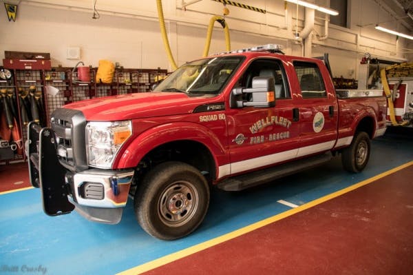 A red fire-rescue truck parked inside a fire station garage.