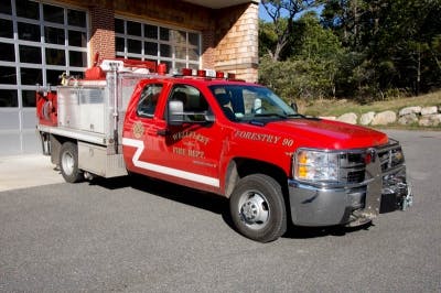 A red fire department pickup truck with forestry equipment.