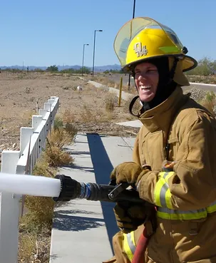 Photo of a firefighter using a hose