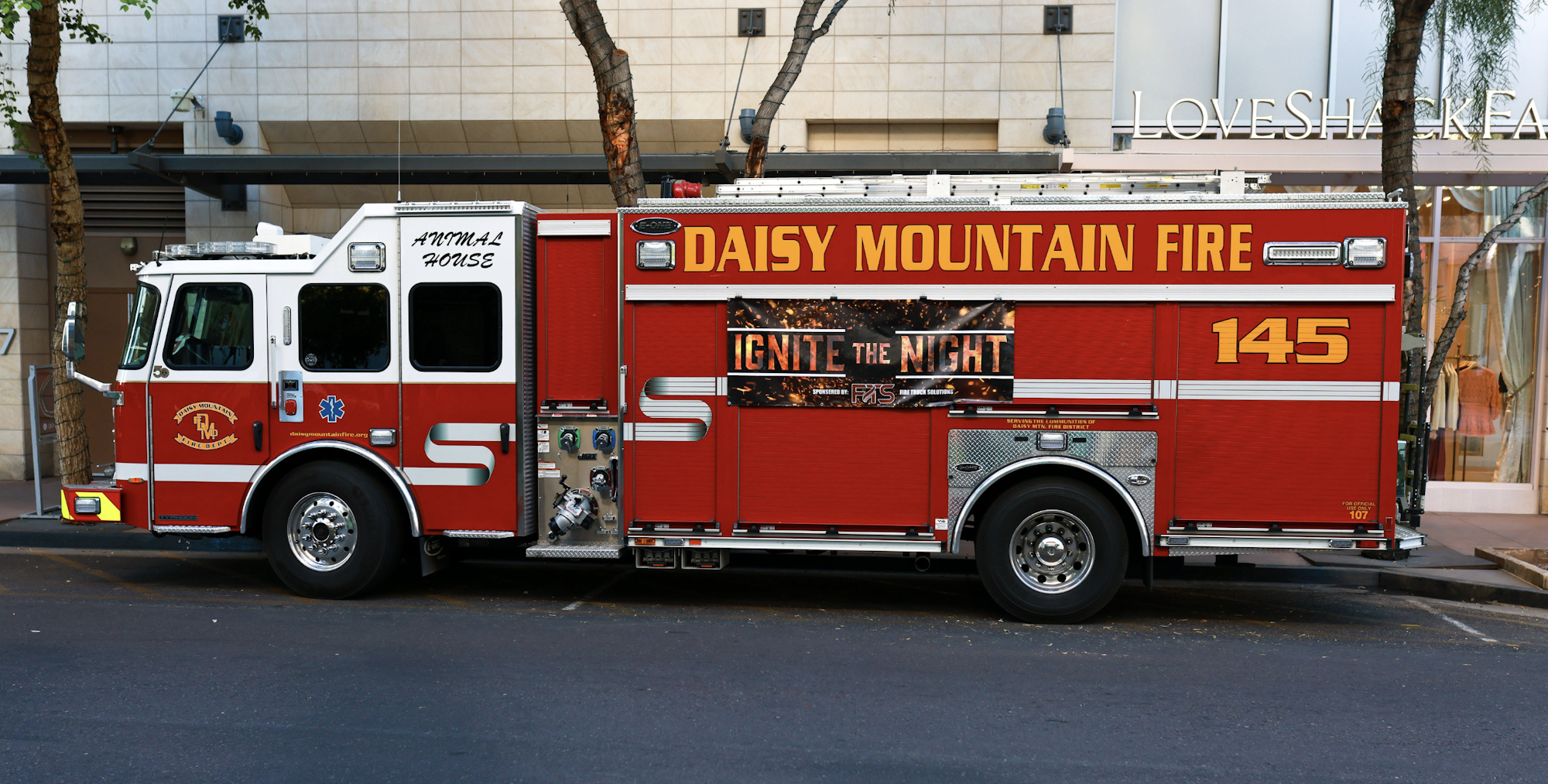 Red fire truck labeled "DAISY MOUNTAIN FIRE 145" parked on a street.
