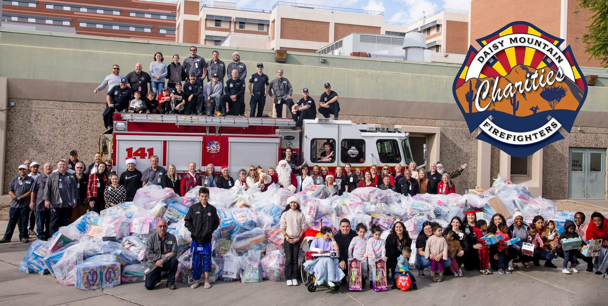 Group of firefighters and community members with gifts, possibly a charity event.