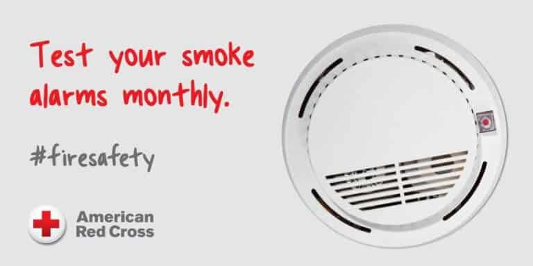 The image encourages monthly testing of smoke alarms for fire safety, featuring a smoke detector and the American Red Cross logo.
