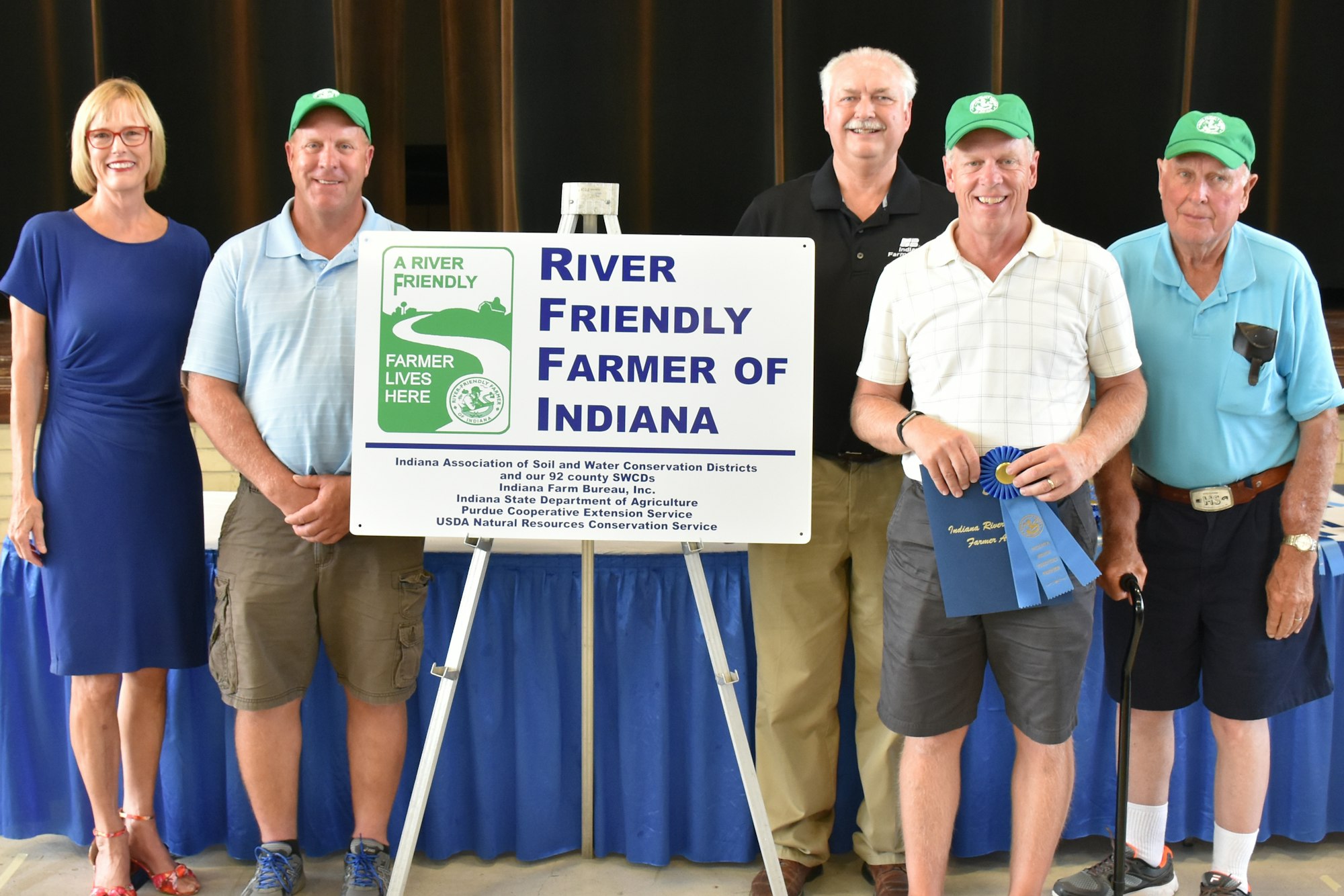 Five people posing with a "River Friendly Farmer of Indiana" award sign.