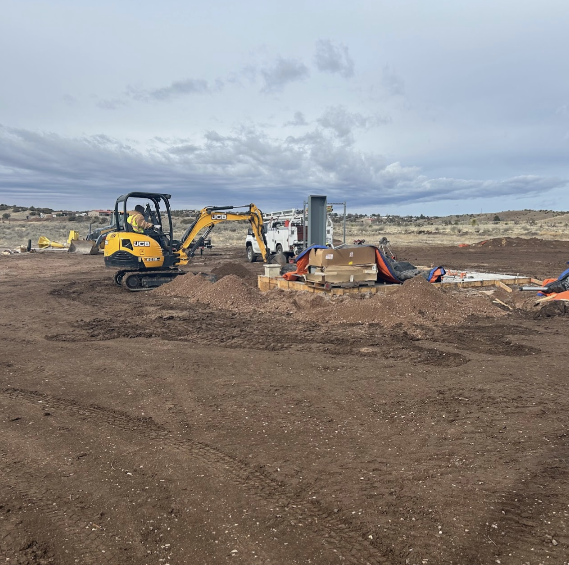 Construction site with excavators, materials, and workers.