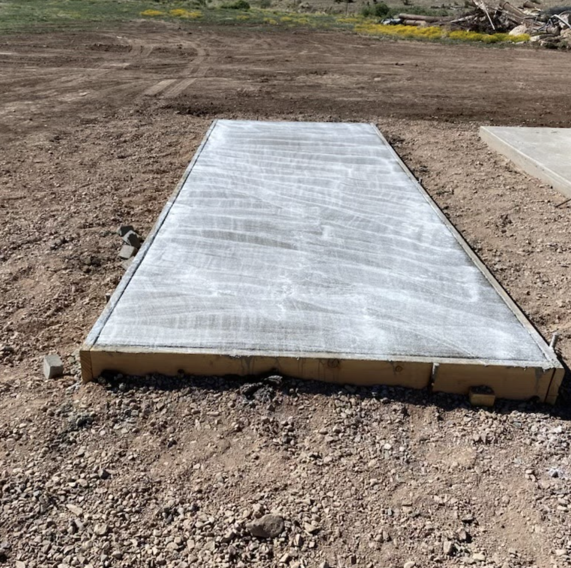 A concrete slab covered with protective fabric on a construction site.