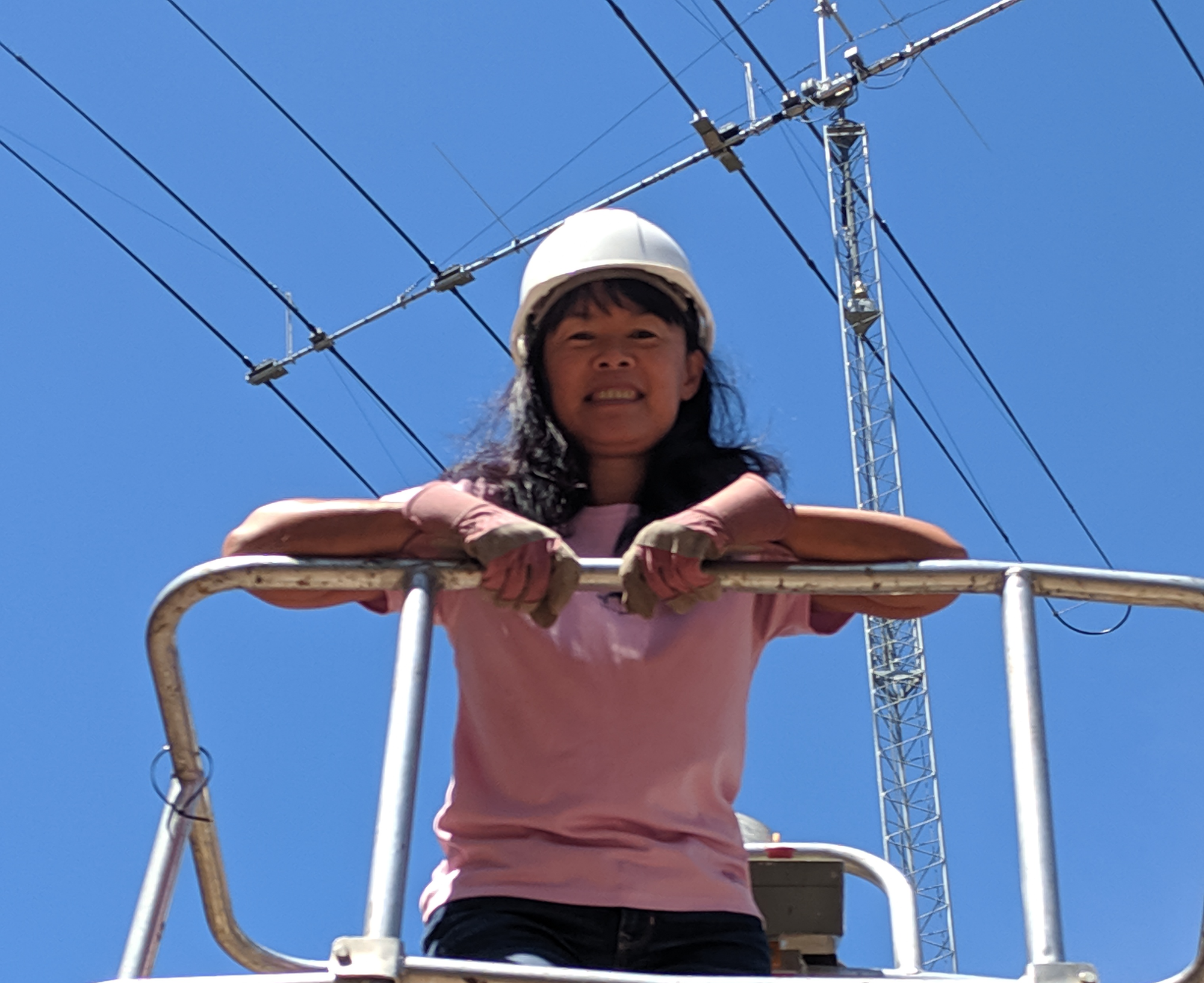 Doris Wong K0BEE in a basket crane used for antenna repairs