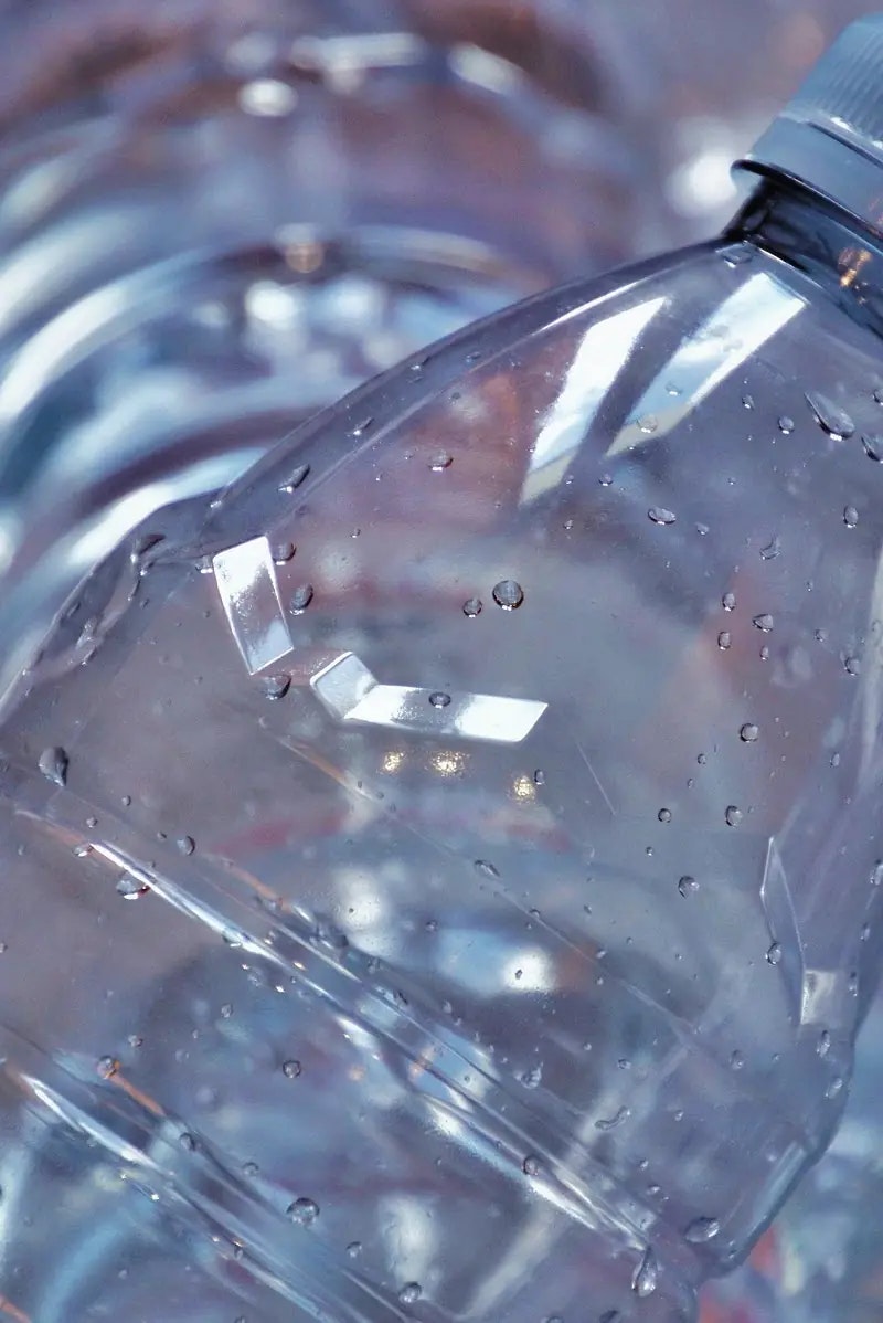 Close-up of a plastic bottle with water droplets on its surface.