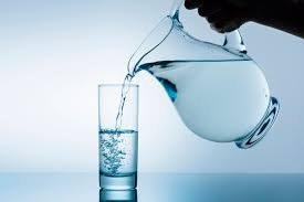 Water being poured from a jug into a glass.