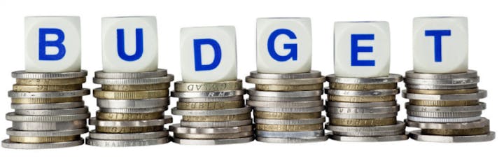 Coins stacked with blocks spelling "BUDGET" on top.