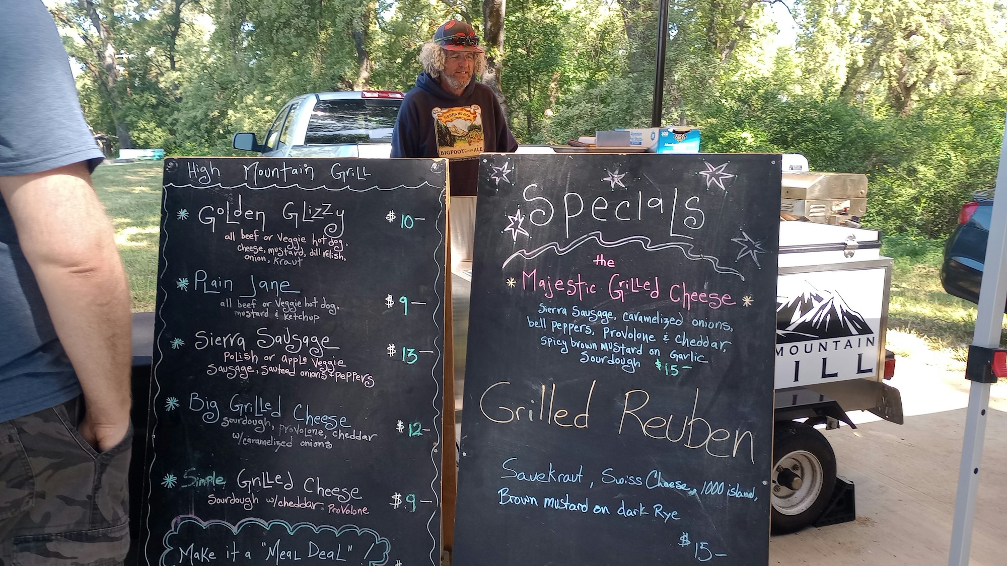 Chalkboard menus with food options at "High Mountain Grill" including hot dogs, sausages, and grilled cheese sandwiches.